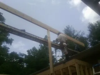 Carpenter setting a ridge beam over a new addition frame — Ice Dam Removal by Roofing Brothers in Chadbourn