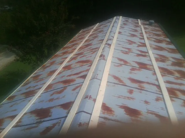 Rusted metal roof panels with new wood purlins before replacement — Storm Damage Roof Repair in Chadbourn by Roofing Brothers