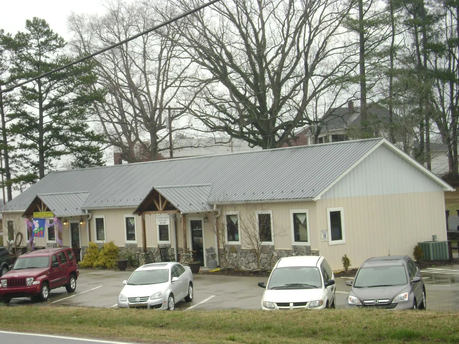 Gray metal roof with timber entry brackets on a small commercial building in Chadbourn